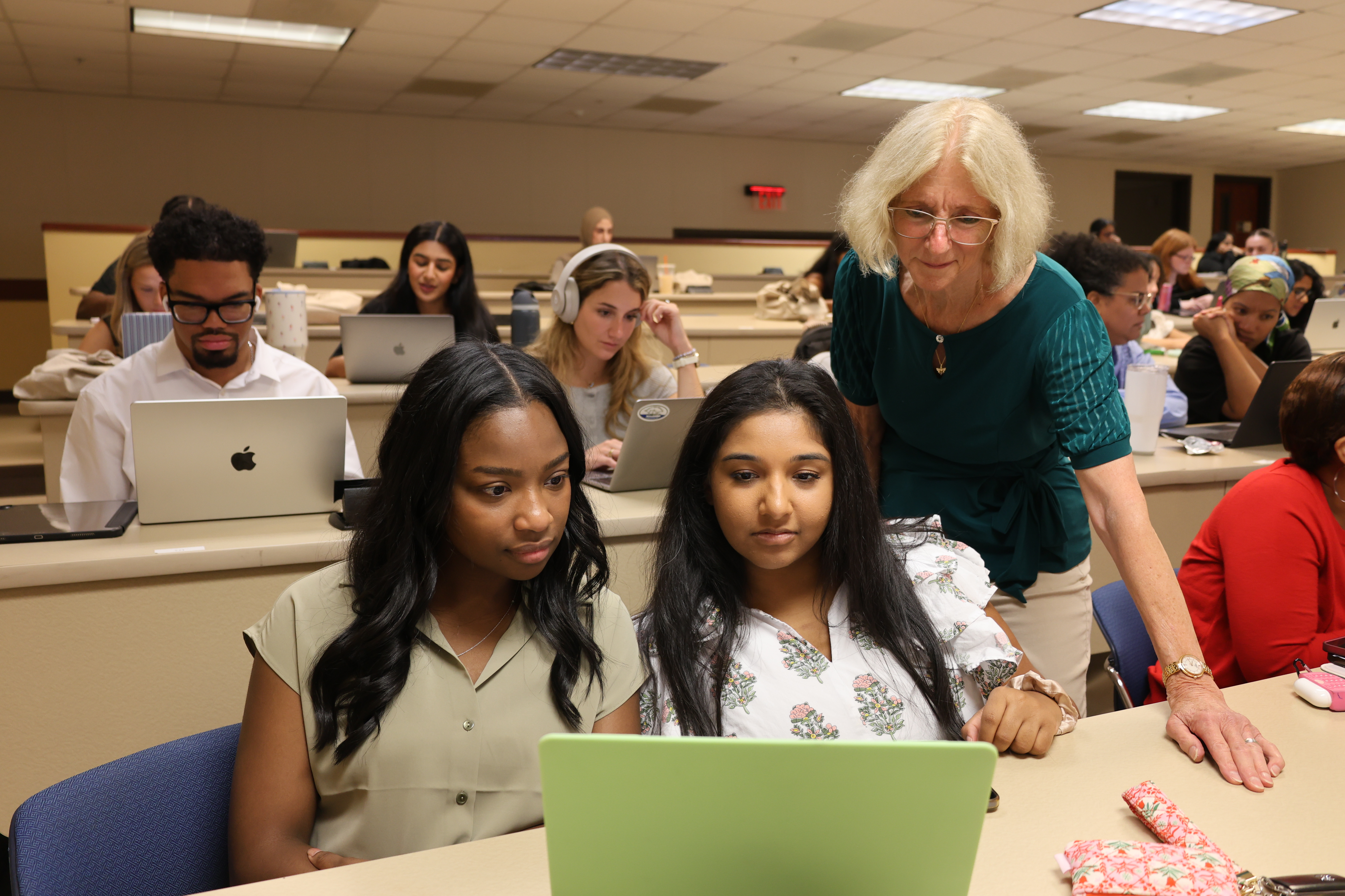 Teacher consulting with a student in a classroom